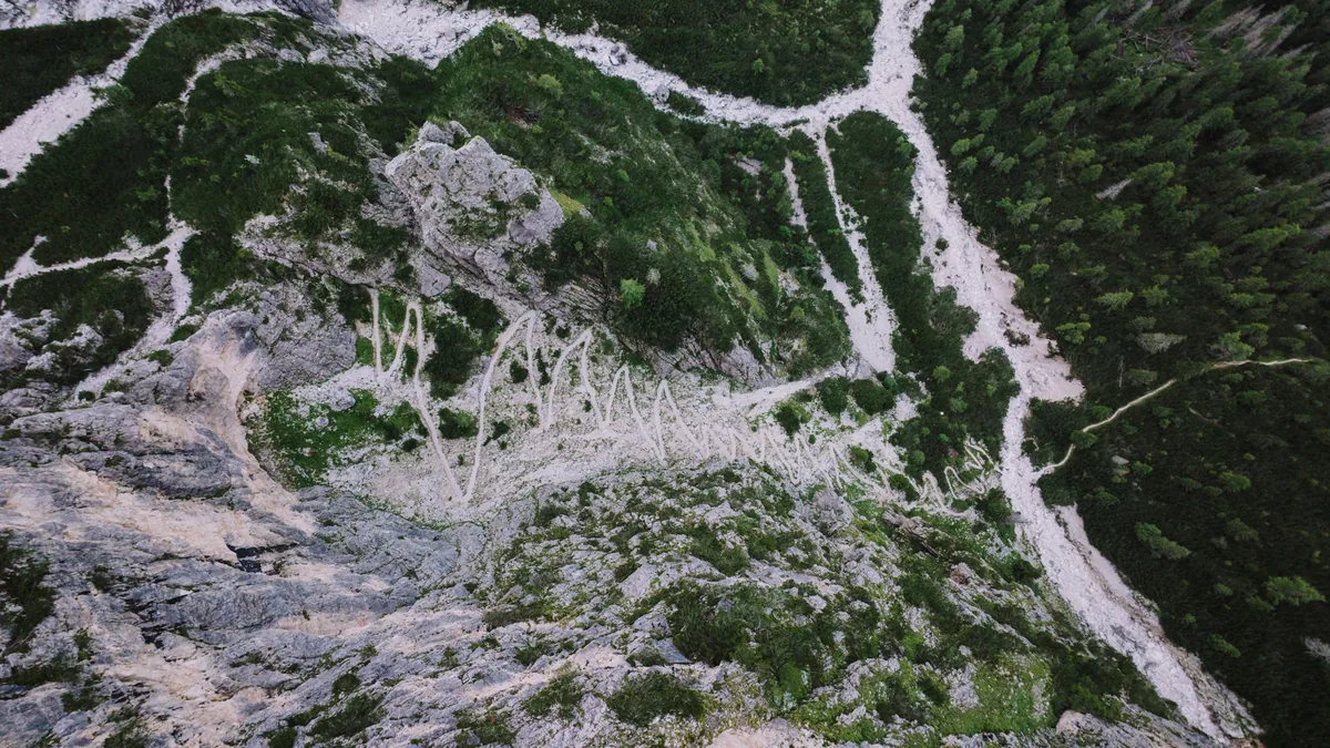 A breathtaking aerial shot of a winding mountain trail in San Martino di Castrozza, Italy.